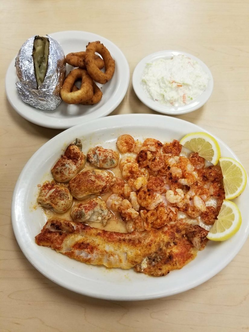 Broiled Alaskan white fish, shrimp and oysters with a baked potato, onion rings and slaw